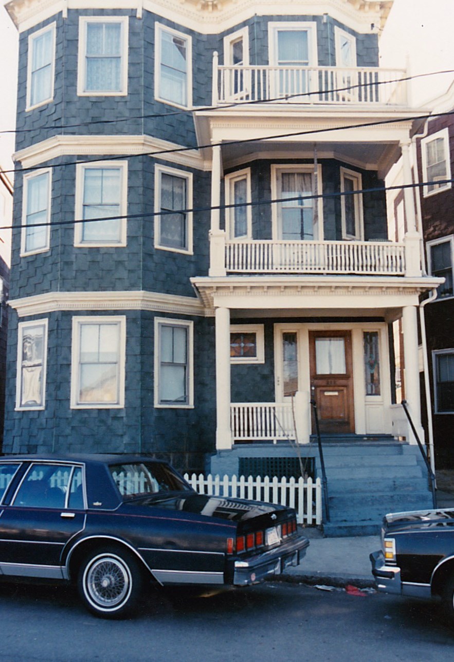 A classic three-story wood-frame triple-decker house with stacked porches in Dorchester.