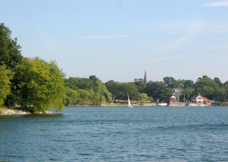 The calm water of Jamaica Pond ringed by trees in the Jamaica Plain neighborhood.